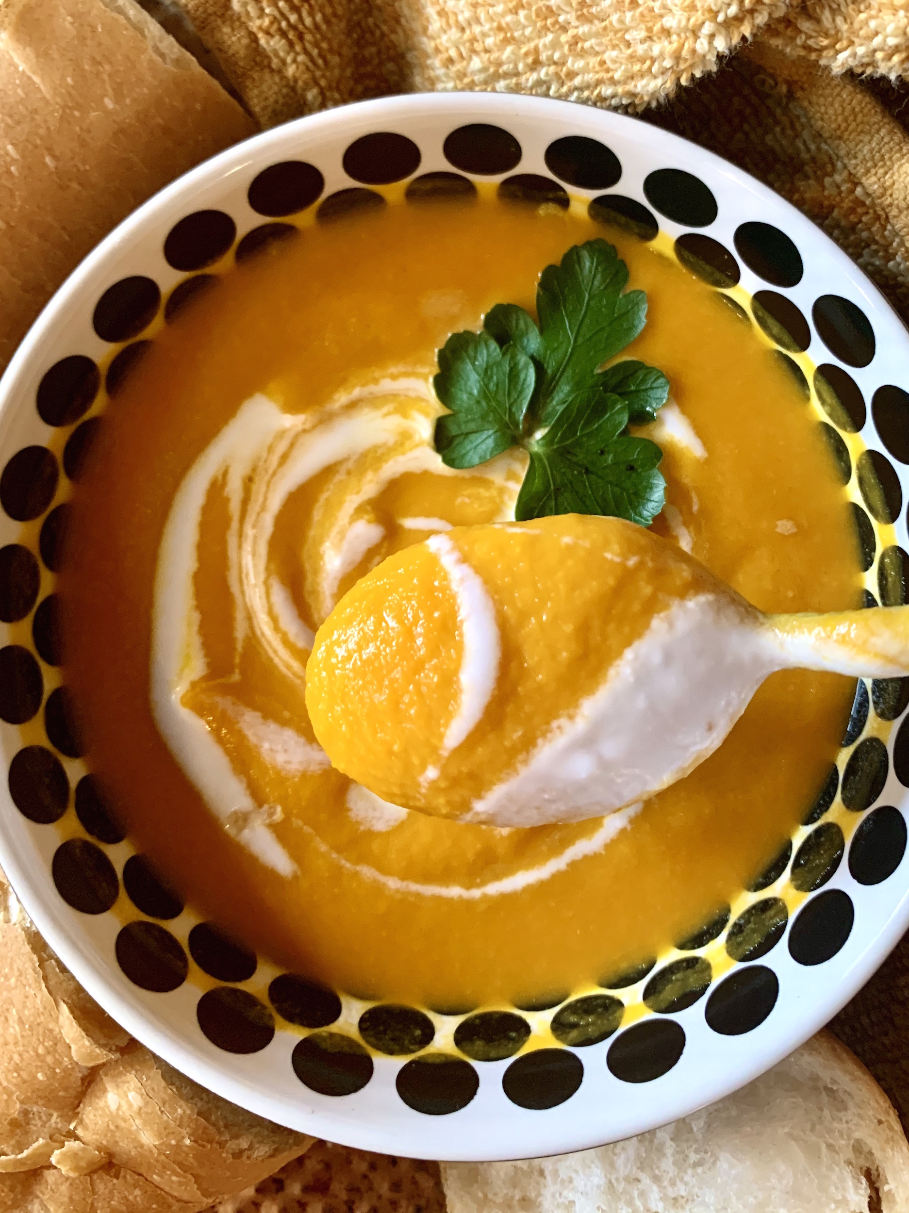 Bowl of carrot ginger soup with a coconut milk swirl