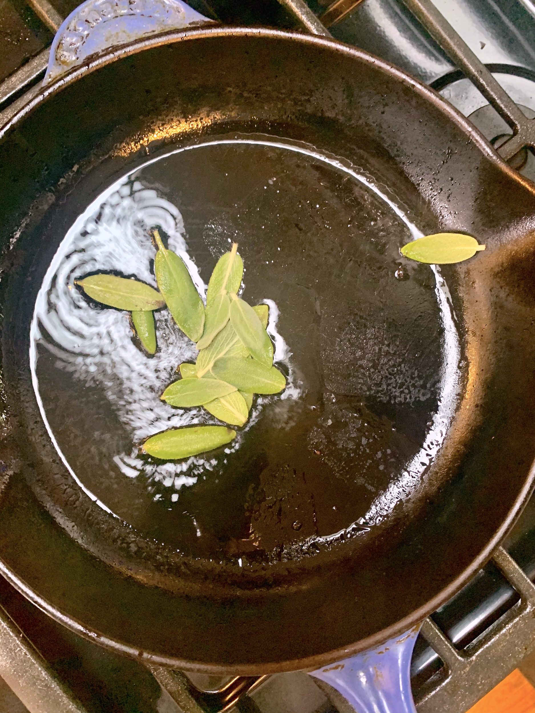 frying sage leaves in a skillet with hot olive oil