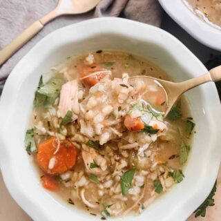 Bowl of Instant Pot Chicken and Rice Soup with a spoonful of soup on a gold spoon.