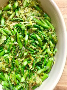 Sauteed leeks and asparagus in buttered oval baking dish