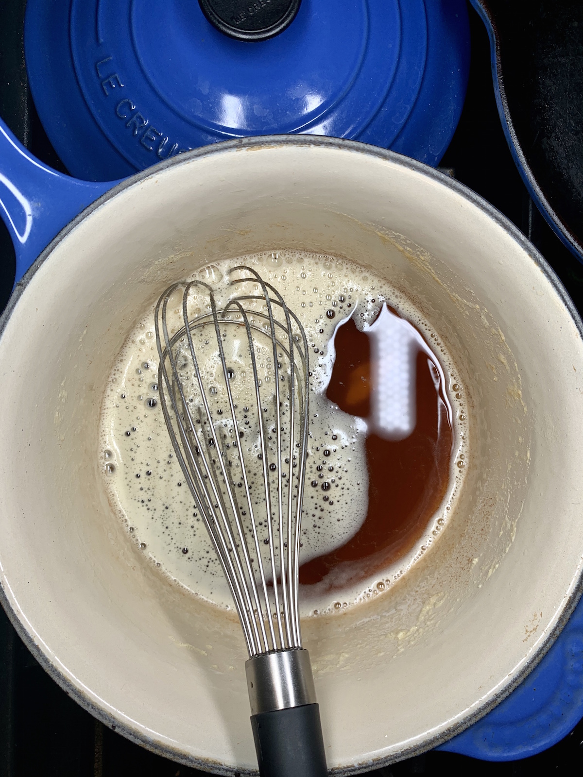 browned butter in a blue saucepan with a whisk