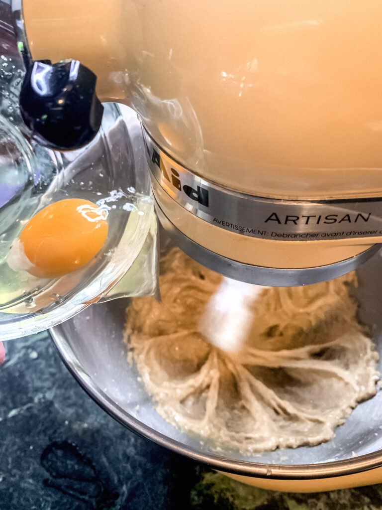 Stand mixer running with egg being added