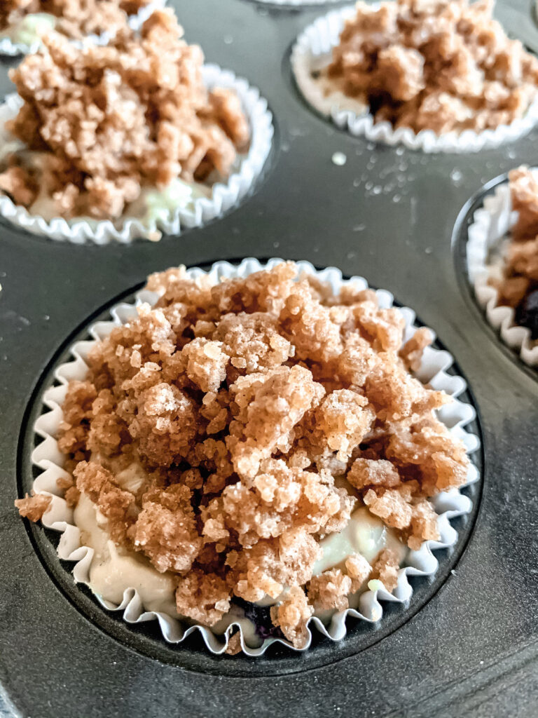 Close up of muffin tin with streusel topped muffin batter