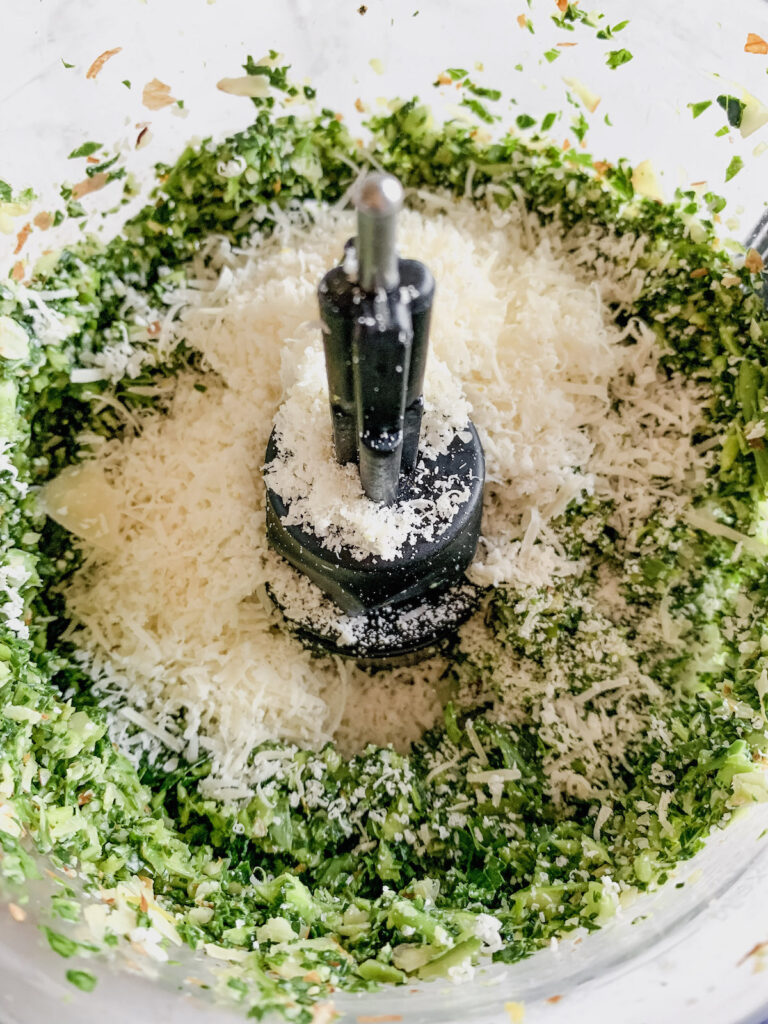 Adding parmesan cheese to bowl of food processor