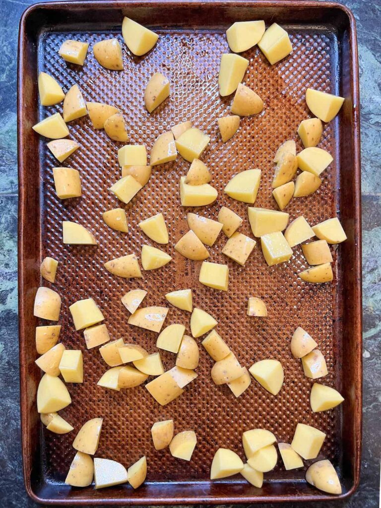 Cut potatoes on a sheet pan.