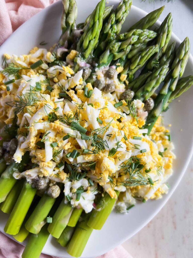Close up of asparagus mimosa on a white platter.