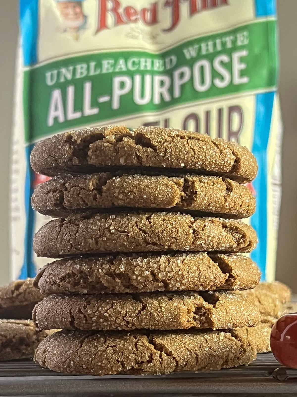 Stack of molasses cookies with a bag of Bob's Red Mill Flour behind them.