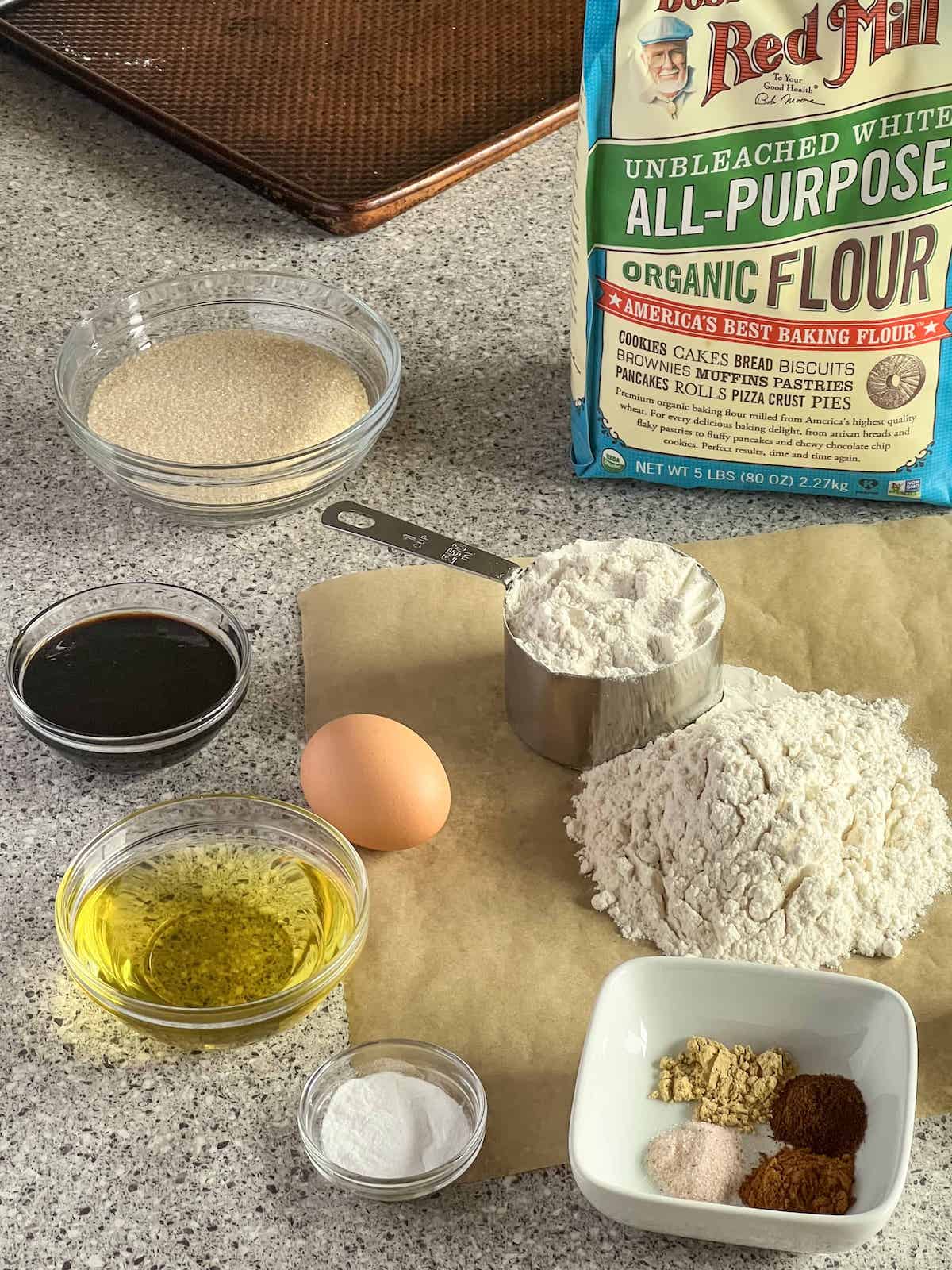 Ingredients for molasses cookies on a granite countertop.