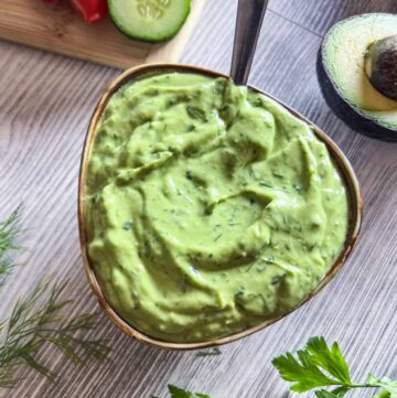Small bowl of avocado ranch dressing with a spoon in it.