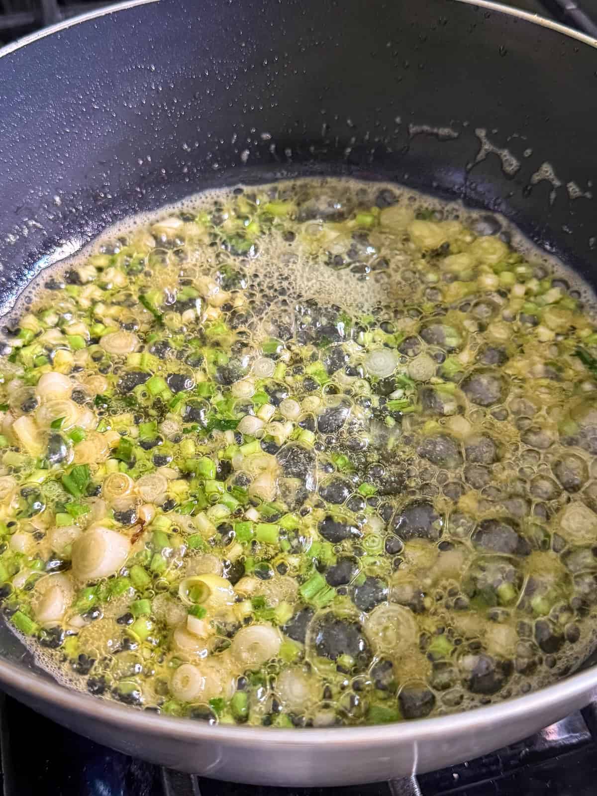 Sautéed ramp bulbs and stems in a pan with melted butter.