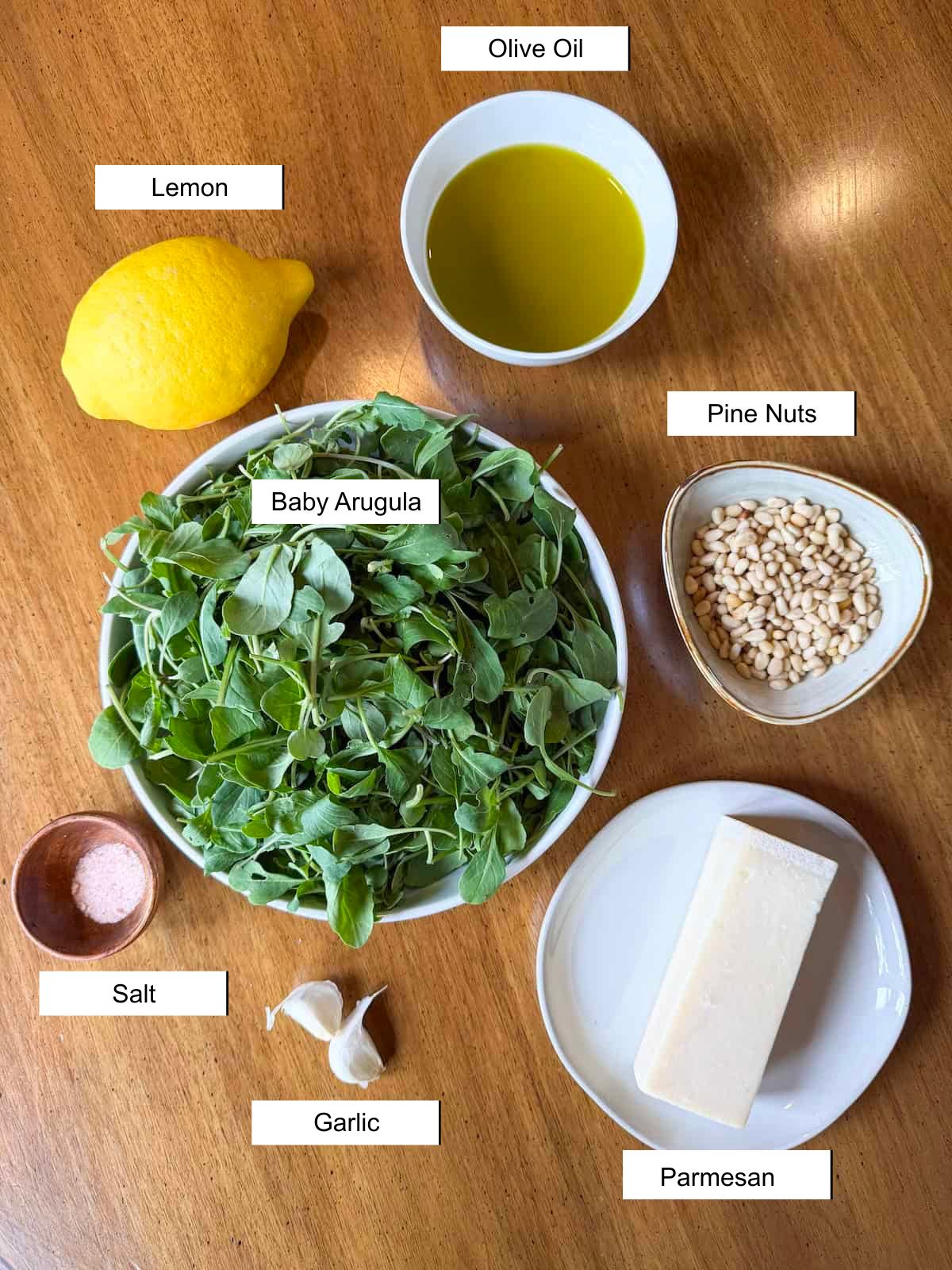 Recipe ingredients in small dishes on a wood table.