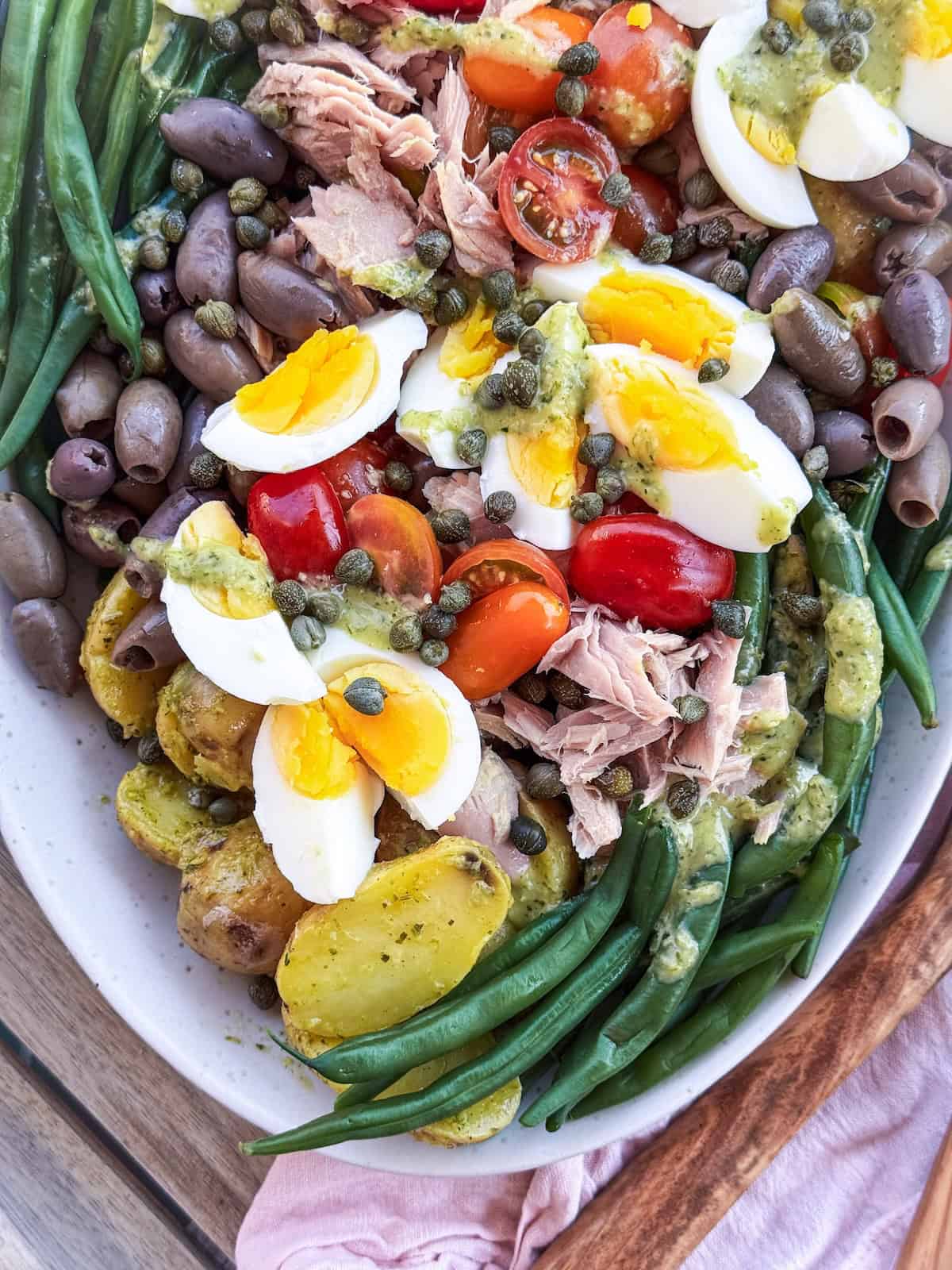 Assembled Nicoise Salad on a white platter.