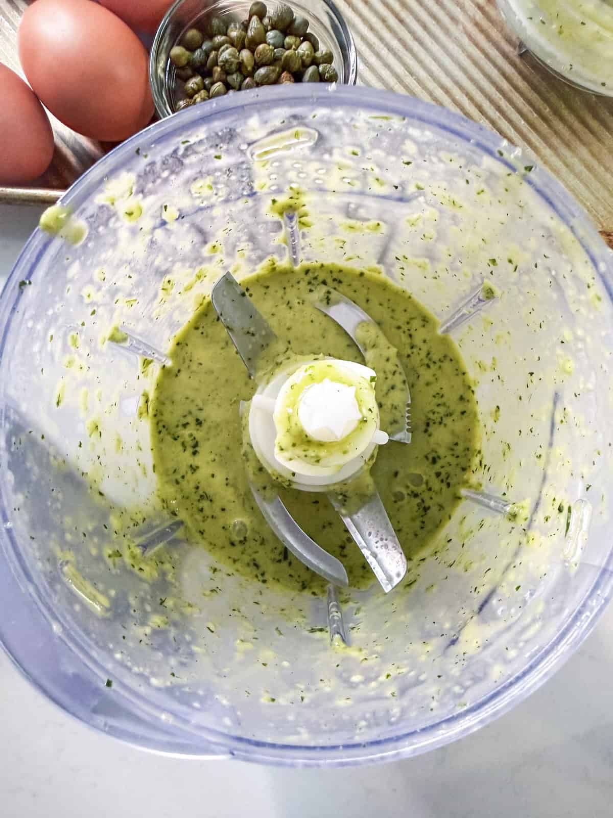 Salad dressing in the bowl of a food processor.