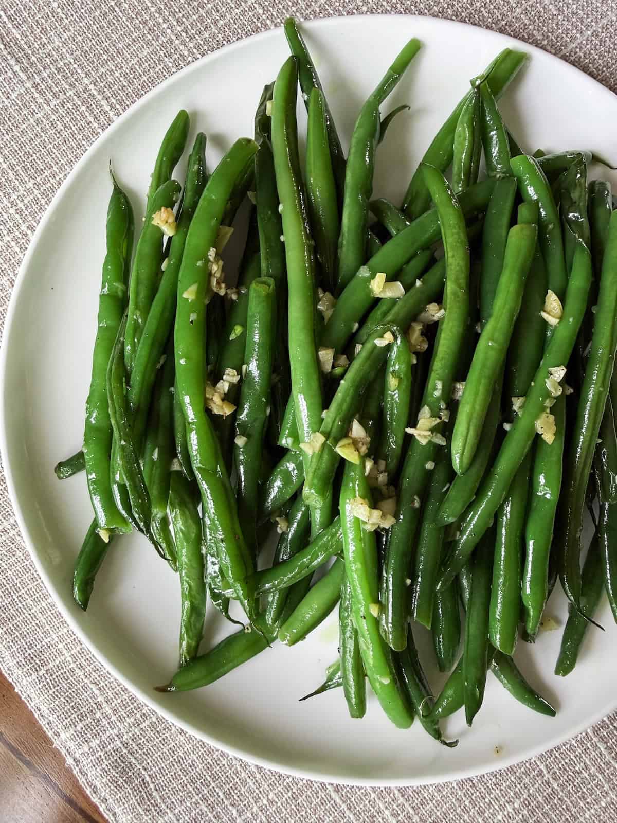 Sauteed Haricot Vert with garlic on a white plate.