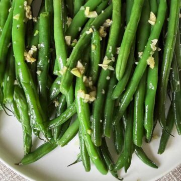 Satueed Haricot Verts with Garlic on a white plate.