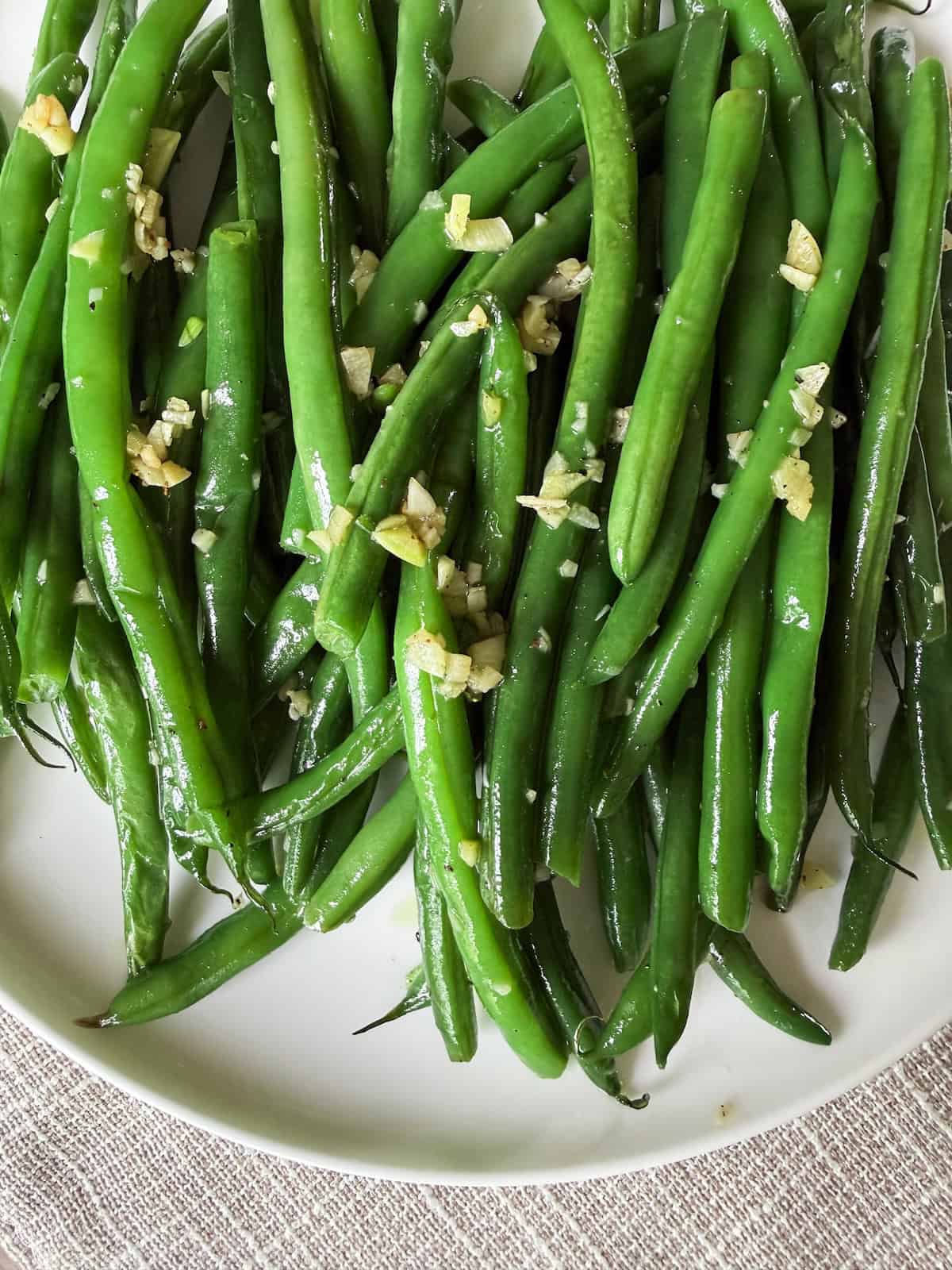 Satueed Haricot Verts with Garlic on a white plate.